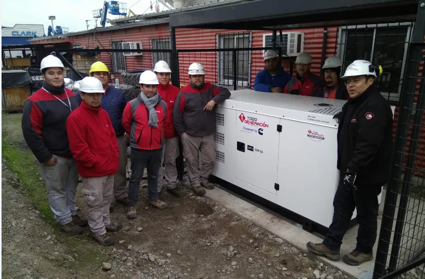 Equipo técnico de TodoGeneración con cascos junto a un grupo generador instalado