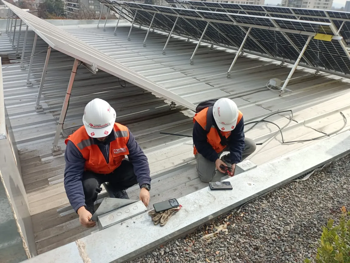 Técnicos instalando paneles solares en una techumbre