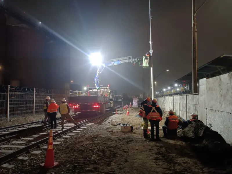 Equipo de TodoGeneración trabajando de noche con iluminación en una vía férrea